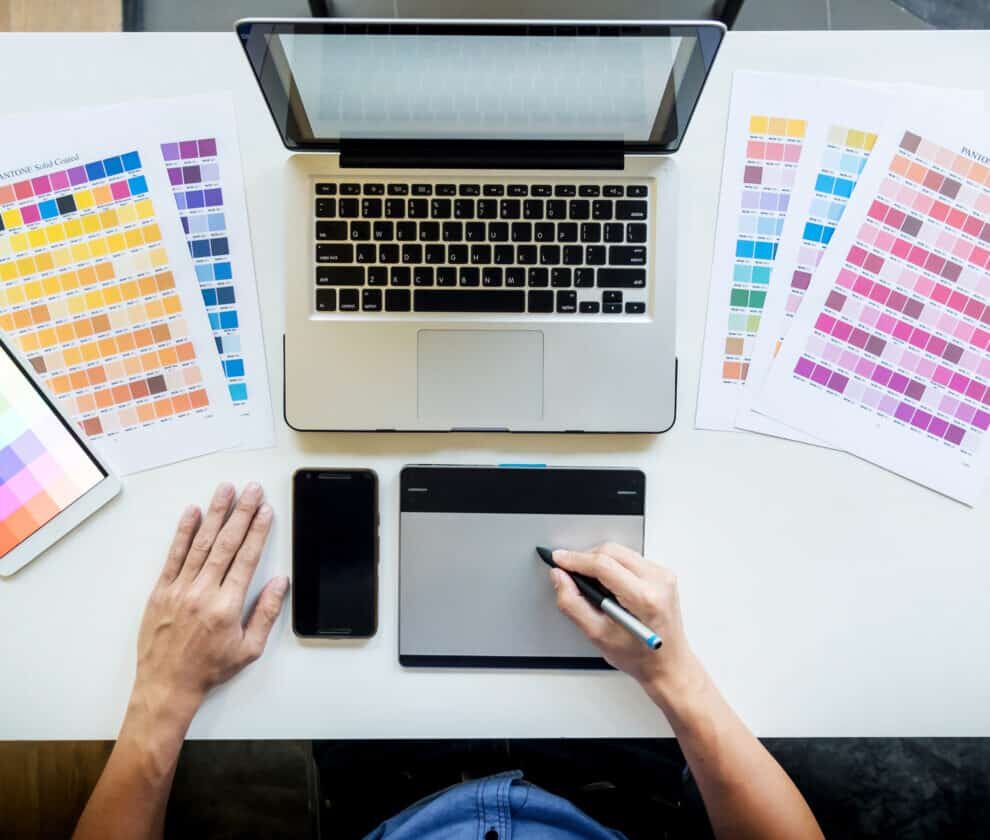 Top view of a young graphic designer working on a desktop comput